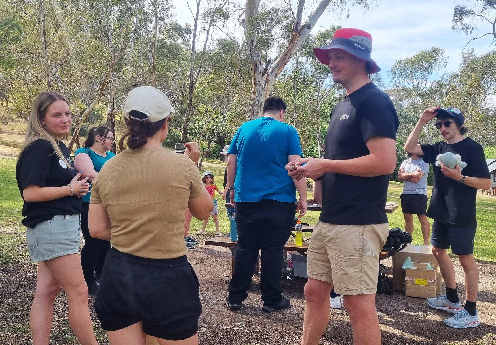 A group of people meet in a parkland